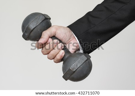 Businessman hand holding heavy dumbbell