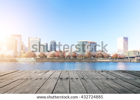 empty wood floor near water with cityscape and skyline of portland