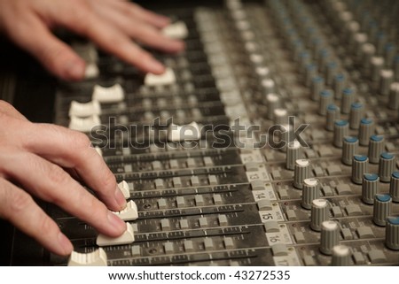sound producer moving fads of dirty sound mixer panel. focus on fingers of right hand