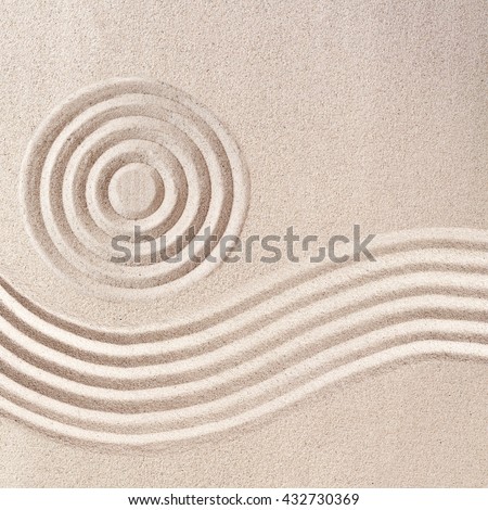 Raked sand patterns in Japanese Zen Garden wit simple flowing waves and concentric circles in a square frame format