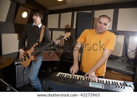 electrical guitar player and keyboarder working in studio