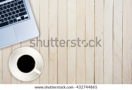 Laptop (notebook) with cup of coffee on wooden table.