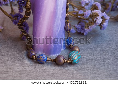 Bohemian jewelry necklace indian with violet flowers and candle. Handmade beads inoriental style of polymer clay.