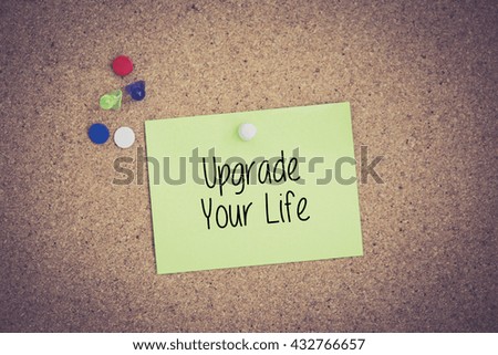 Upgrade Your Life written on sticky note pinned on pinboard