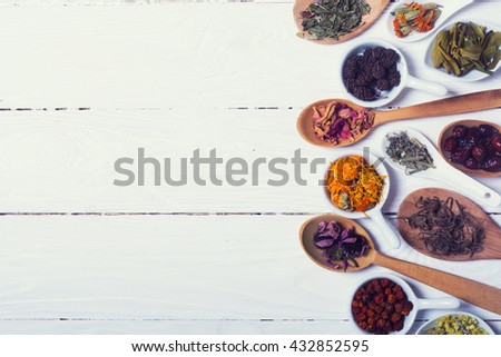 Herbs , berries and flowers on color wooden table background