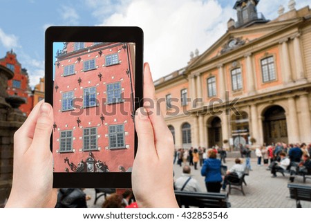 travel concept - tourist photographs facade of old historical house on stortorget square near swedish academy in stockholm on tablet pc