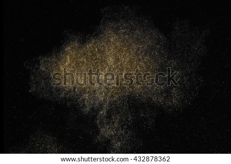 Gold dust glitter shooting on black background