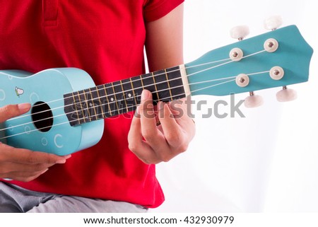 woman's hands playing acoustic Ukulele
