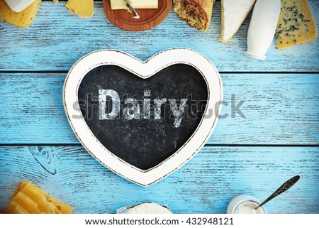 Text dairy in frame of fresh products on blue wooden table