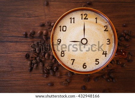 Brown ceramic cup of coffee decorated with roasted beans around on wooden background. Time concept