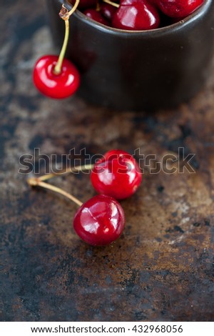 Red cherries in a black vintage cup