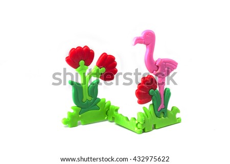 Plastic toy flamingo and flowers isolated on white background.
