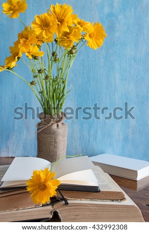 Beautiful spring flowers in a vase with books and note