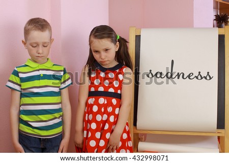 the development of emotional intelligence. child psychology. girl and boy depict different emotions. against the background of the drawing board