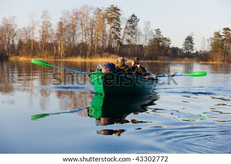 Tourists by a boat on spring lake