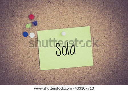 Sold written on sticky note pinned on pinboard