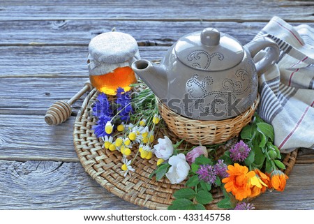 Teapot with various herbal,  honey on wooden table 