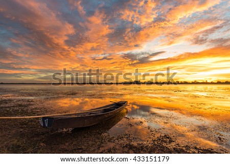 Small fishing boats beached on the riverbank in the park at sunset.
Shows a silhouette of a beautiful sky reflected from the water surface. Royalty-Free Stock Photo #433151179
