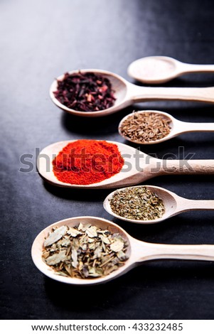 spice in wood spoon on a black background. food