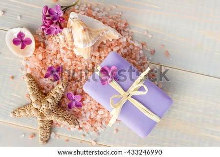 Organic spa soaps with lilac flowers and sea salt on white wood table. Top view
