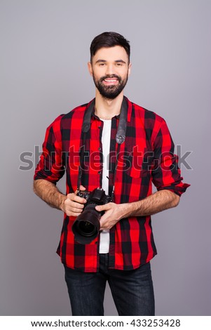 Handsome young bearded happy man holding professional camera