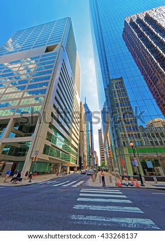 Arch Street view with skyscrapers reflected in glass in the City Center of Philadelphia, Pennsylvania, USA. It is central business district in Philadelphia. Tourists in the street