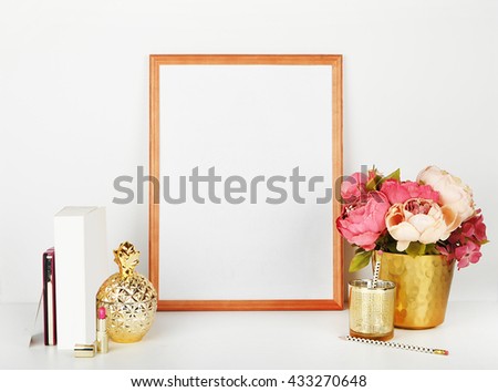 Frame Mock-up for your photo or text . Place your work. Wood frame with gold vase and gold items. gold vase and peonies. White book. 