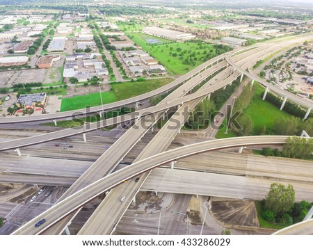 Aerial view massive highway intersection, stack interchange with elevated road junction overpass at early morning in Houston, Texas. This five-level freeway interchange carry heavy rush hour traffic.