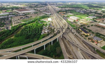 Aerial view massive highway intersection, stack interchange with elevated road junction overpass at early morning in Houston, Texas. This five-level freeway interchange carry heavy traffic, panorama.