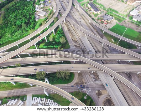Aerial view massive highway intersection, stack interchange with elevated road junction overpass at early morning in Houston, Texas. This five-level freeway interchange carry heavy rush hour traffic.