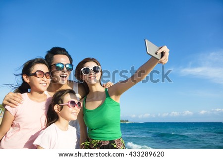happy family taking a selfie at the beach