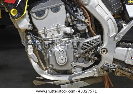 Detailed closeup of a four-stroke dirt bike engine isolated on black background.
