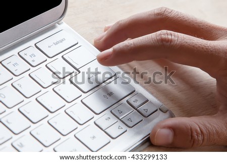Close-up of male forefinger on button on tablet computer.