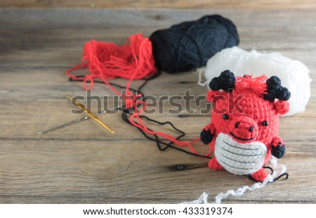 Crochet  dragon doll on wood background