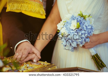 groom and bride  puts his hand on the holy book