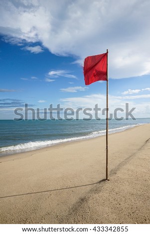 warning sign of a red flag at a beautiful clean beach with a blue sky, cloud and the sea, High contrast and colorful picture style