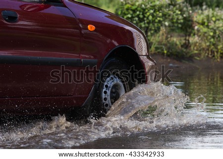  cars driving on a flooded road during a flood caused by heavy rain, 