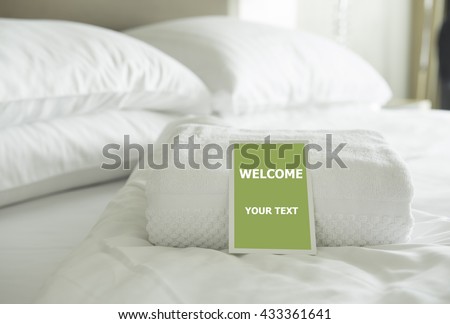 Welcome card placed inside a hotel room bed with green apple. With clipping path on card.