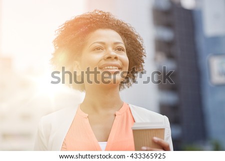 business and people concept - young smiling african american businesswoman with coffee cup in city