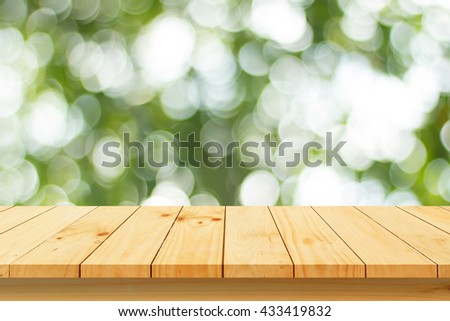 Wood table top on shiny bokeh green background. For product display