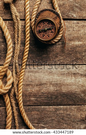 ship ropes and compass on wooden background