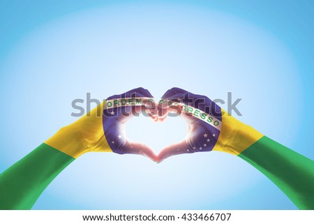 Brazil flag on people hands in heart shape for labor day national holiday celebration and pray for Brazilian isolated on blue sky background