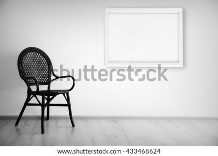 Cozy chair and picture frame on wall background