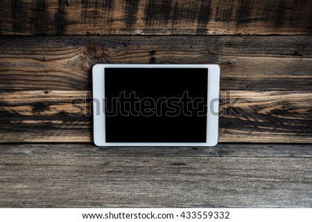 White tablet computer on wooden background