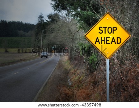 STOP AHEAD road street sign in rural country landscape.