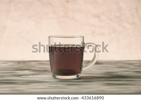 Cup of tea on light wooden table on blur jute background. Selective focus. Shallow depth of field. Toned.