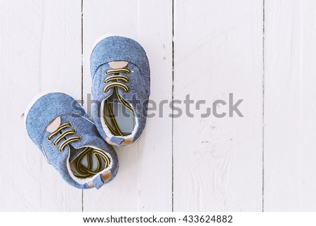 Baby shoes on wooden background Royalty-Free Stock Photo #433624882