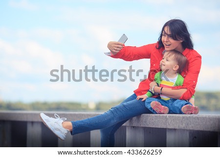 Family and technology. Cute little baby girl and her mother taking selfie. 
