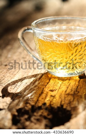 Low key picture, shilouette of tea cup on a wood background. Selective focus