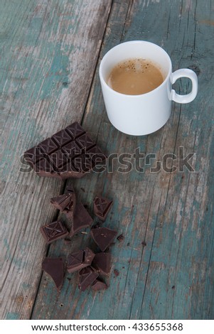 Dark chocolate and a cup of coffee on old, vintage table, stock photo